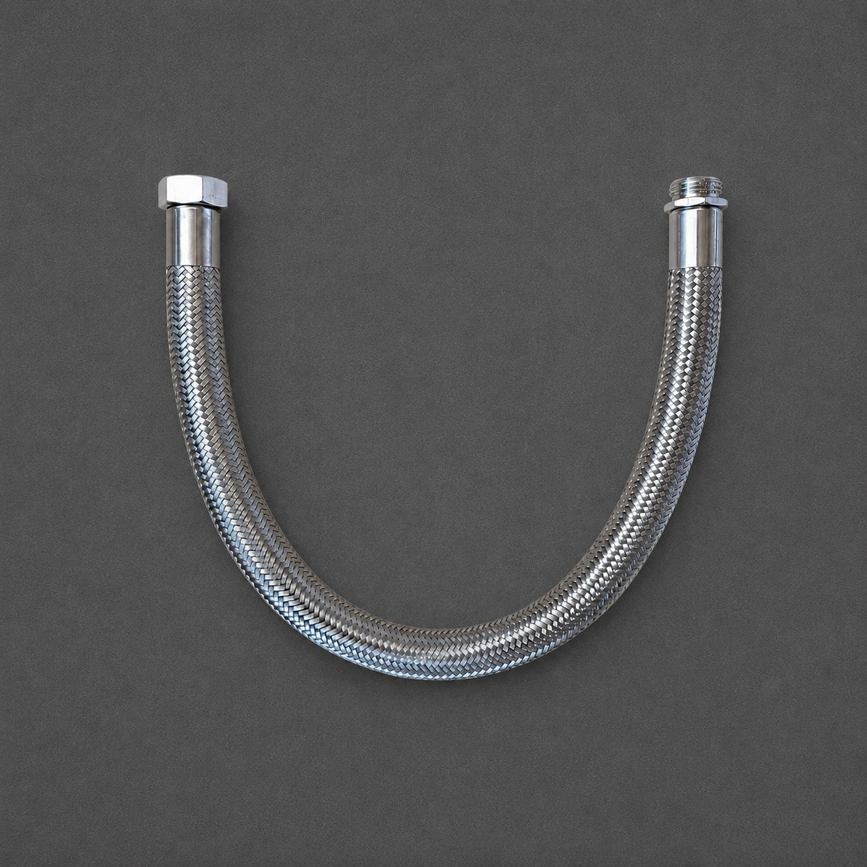 A curved stainless steel braided hose with hexagonal and threaded metal connectors on both ends, shown against a dark gray background.