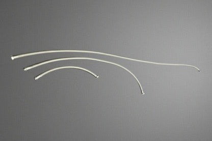 Three curved stainless steel braided hoses of varying lengths laid out on a gray mat
